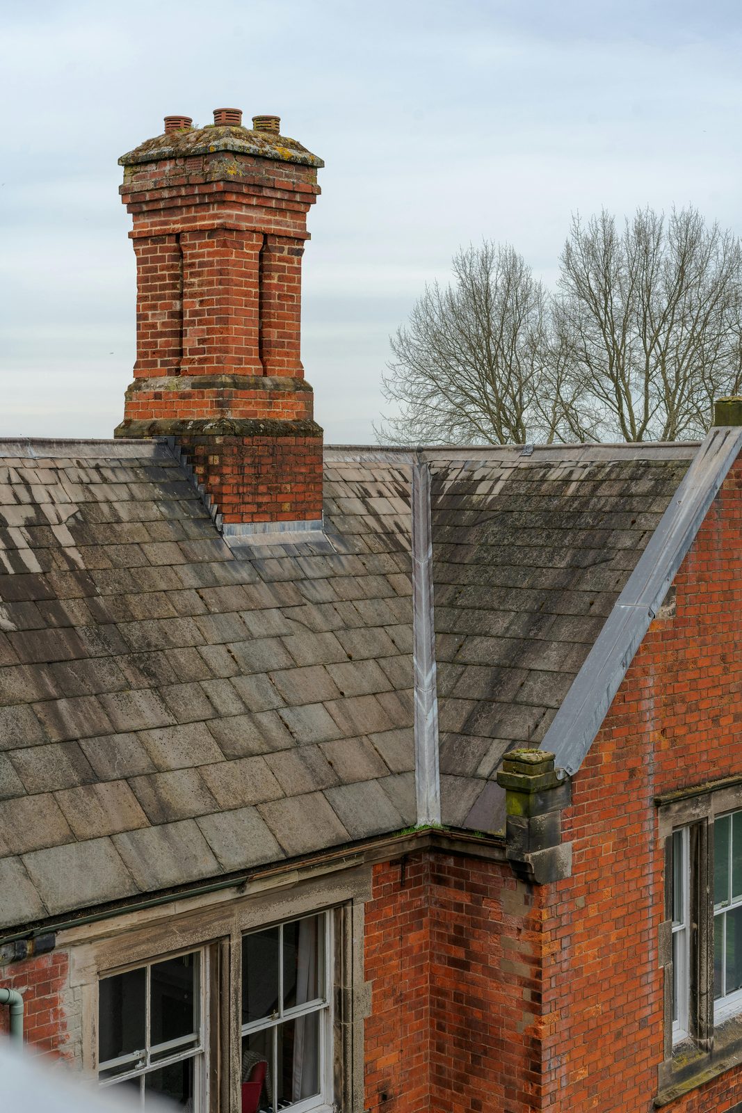 Brick chimney on a slate-roofed heritage building