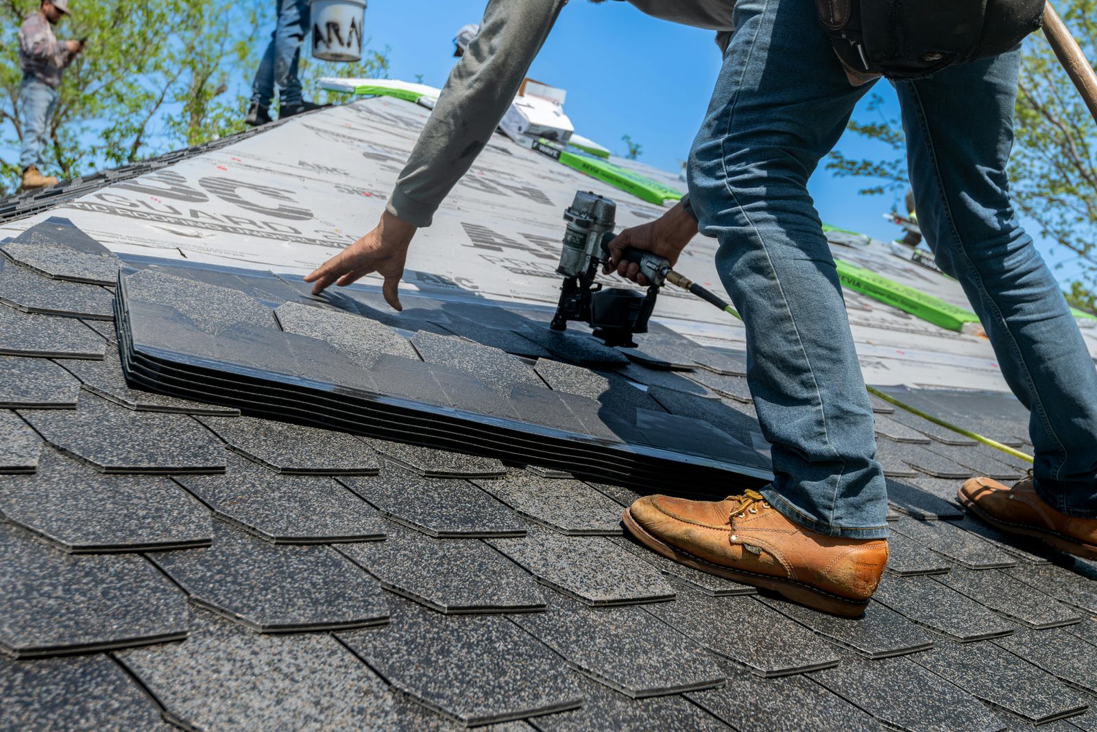 Roofer laying shingles on a pitched roof